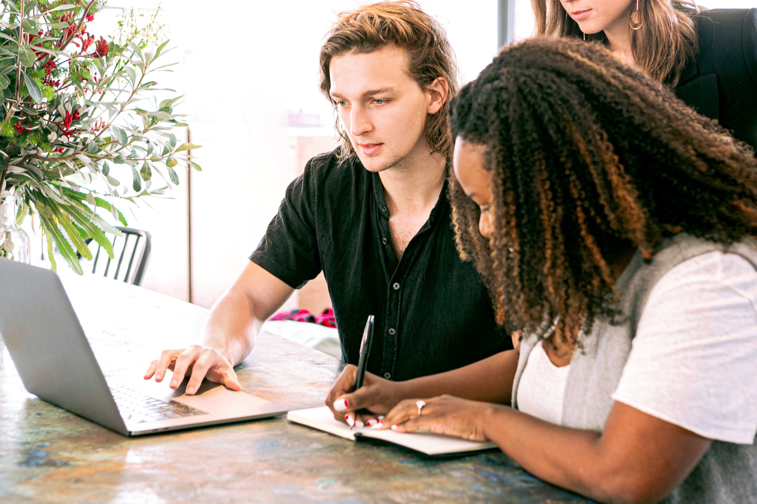 Four students working together on a document at a table.